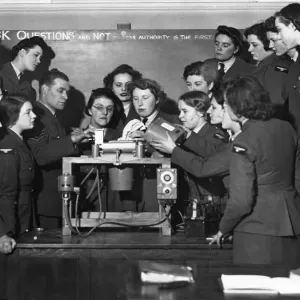 Members of the Womens Auxiliary Air Force being taught to fit the magazine in an