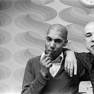 Two men with "Kojak"hair cuts. 1975