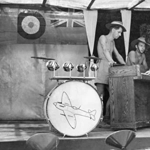 Men of the Royal Air Force spend their lunch time break with a song at the piano in their