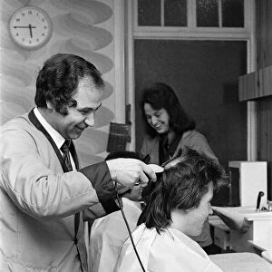 Two men who are getting "Kojak"hair cuts. 1975