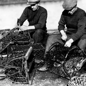 Mending their nets - Amble fishermen repairing their crab pots on the pier Mending their nets - Amble fishermen repairing their crab pots on the pier