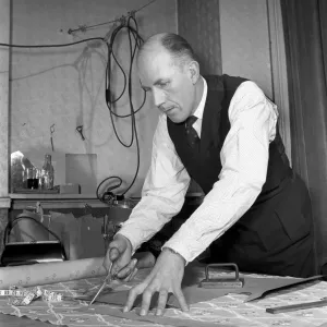 Mens Fashions: Tailor measuring and sewing in his workshop Mens Fashions: Tailor measuring and sewing in his workshop