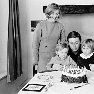 Michael Aspel tv presenter with his family blowing out birthday cake candles