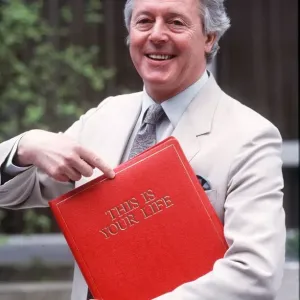 Michael Aspel holding red book Print Michael Aspel holding red book Print