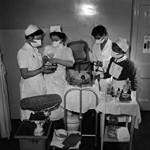 Midwives help delivery a two pound baby which was placed in an incubator. May 1953 D2623