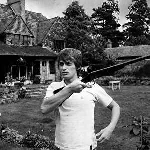 Mike Oldfield muscian at home holding a gun
