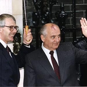 Mikhail Gorbachev stands with John Major under umbrella outside 10 Downing Street 1991