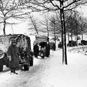 Miles of transport forge ahead through the snow covered grounds of the Ardennes salient
