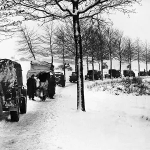 Miles of transport forge ahead through the snow covered grounds of the Ardennes salient