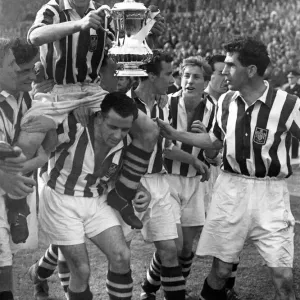 Millard, el capitán del West Brom que sostiene la FA Cup es llevado en hombros por sus colegas.
