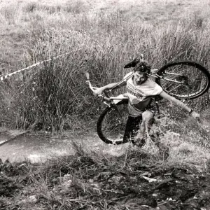 Mind how you go... a competitor carries his cycle across one of the many bogs negotiated