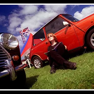 Mini car August 1999 Woman sitting leaning against red Mini in the sun reading brochure