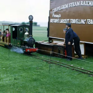 Un tren de ferrocarril miniatura perteneciente a la Compañía del Ferrocarril de Vapor El Peregrino con pasajeros. Un tren de ferrocarril miniatura perteneciente a la Compañía del Ferrocarril de Vapor El Peregrino con pasajeros.
