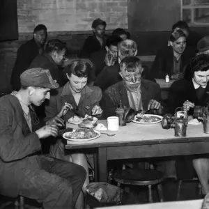 Mining coal miners. Miners straight from the coal sitting down with women folk of Mining coal miners. Miners straight from the coal sitting down with women folk of