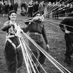 Print of a Ministry worker learning parachute handling from RAF paratroop Print of a Ministry worker learning parachute handling from RAF paratroop