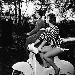Miss Cycling 1959 riding a Scoo-ped and Miss Cycling 1898 riding an old-fashioned sit up