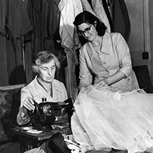 Miss Marion Agar, wardrobe mistress (right) helps Mrs May Finch, the dressmaker