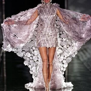 Top model Adriana Karembeu sports a metallic short dress under a white cape designed by