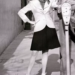 Model April Ashley wearing a white blazer polka dot scarf