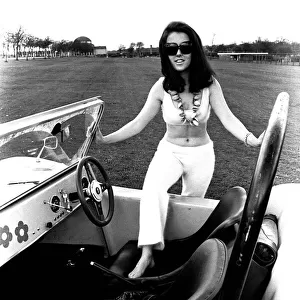 A model in a beach buggy wearing a blouse and trousers in April 1970