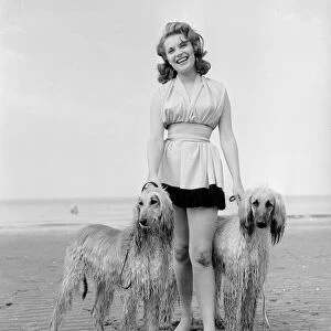 Model Belinda Lee seen here with here Afghan hounds on the beach at Cliftonville, Kent