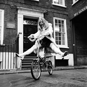 Model Blanche Webb wearing a fur jacket, riding a bicycle. November 1969 Z11350-002