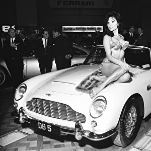 Model drapped over the bonnet of an Aston Martin DB5 at the British International Motor