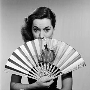 Model with fan in strapless dress. Circa 1964