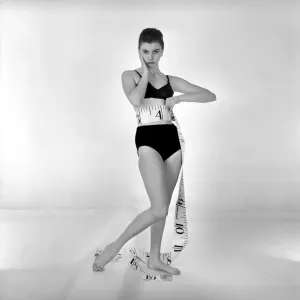 Model Gay Protheroe with outsize tape-measure. December 1956