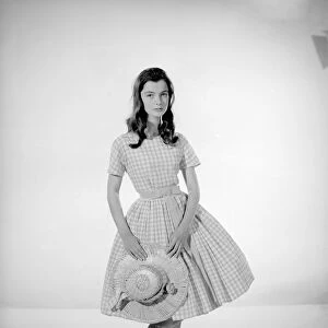 Model Jennifer Goddard. Brown-haired girl in checkered dress with hat