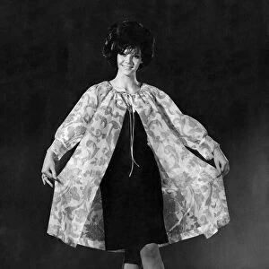 Model Jo-Ann Asher wearing a knee length dress with coat over the top. July 1965