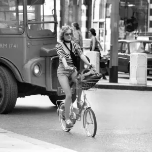 Model riding a bicycle in Kings Road Chelsea, London. April 1975 75-2156-009 Model riding a bicycle in Kings Road Chelsea, London. April 1975 75-2156-009