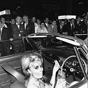 Model takes ker linch break from draping over cars at the 1966 London Motor Show 18th