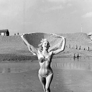 A model wearing a bikini as she enjoys the sun on the beach at Hove March 1959