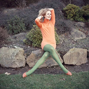 Model wearing full length orange sweater and green matching stockings