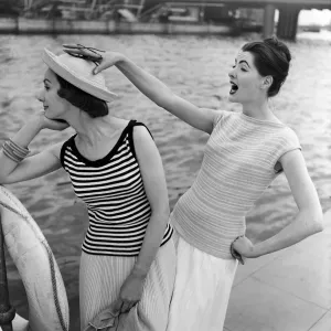 Models by a river, one is wearing a striped cotton sweater. 14th June 1957 Models by a river, one is wearing a striped cotton sweater. 14th June 1957