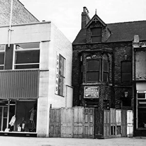 Next to a modern shop front next to a boarded up house, Linthorpe Road. 16th June 1966