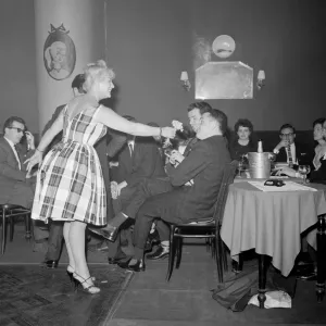 Monte Carlo Rally winner Paddy Hopkirk enjoys the attention of a hostess in a Monte Carlo