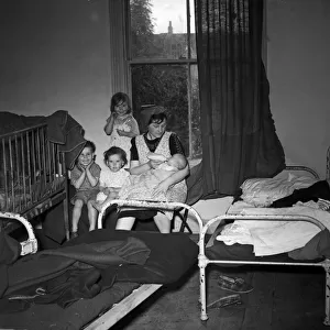 A mother of No. 198 Colman Street, Hull, with her children in one bedroom. 9th July 1953