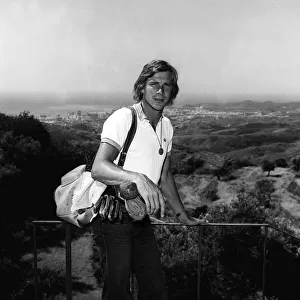Motor racing driver James hunt on holiday in Spain 1975 with his golf clubs
