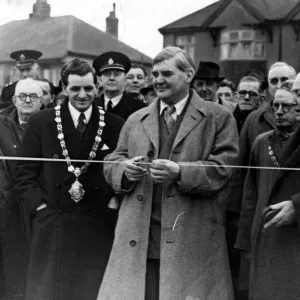Mr Aneurin Bevin, M. P. about to cut the tape across Bevin Crescent Mr Aneurin Bevin, M. P. about to cut the tape across Bevin Crescent