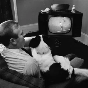 M. David Corbett et Pickles le chien regardent la finale de la Coupe du monde sur un écran de télévision.