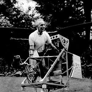 Mr. Harry Killick carries his home built man powered helicopter back to his workshop