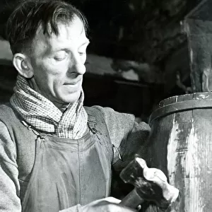 Mr. John parker, a cooper for 30 years, at work on a rum cask bound for one of Her