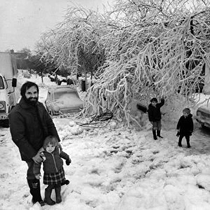 Mr Robert Cowley, of Cyncoed in Cardiff, outside his ice covered garden with his children