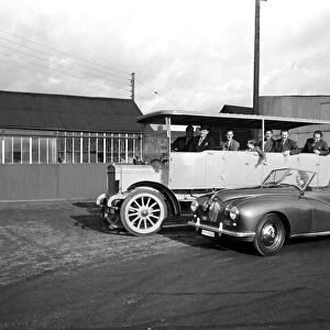 Mrs. W. A. Hudson seen here passing a vintage coach in her new sports car