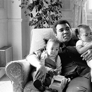 Muhammad Ali cuddling and kissing his daughters Laila, (left )and Hana (right