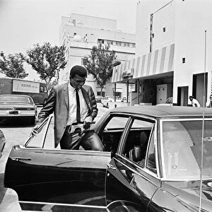 Muhammad Ali getting back into his car after meeting some of his fans