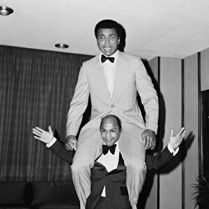 Muhammad Ali getting a piggy back from another guest at a press conference