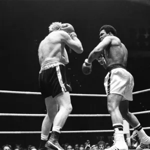 Muhammad Ali frappe un coup de poing alors que Richard Dunn tente de se protéger à Munich. Muhammad Ali frappe un coup de poing alors que Richard Dunn tente de se protéger à Munich.